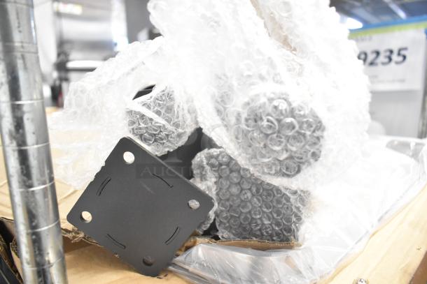 Box of 4 metal legs, brand new, wrapped in bubble wrap; minor dents visible. Ideal for furniture use.