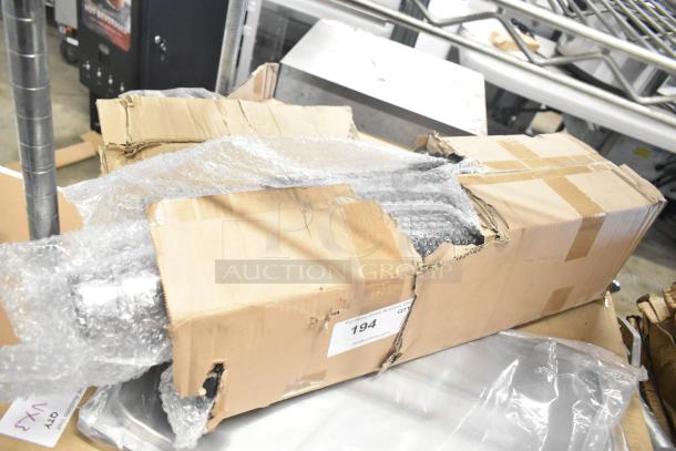 Box of 4 brand new legs, bubble-wrapped, in a damaged cardboard box. Box shows label with auction details.