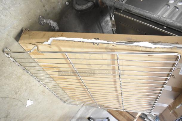 Three brand new scratch and dent metal racks, partially unpacked. Visible damages on packaging. Auction includes multipack.