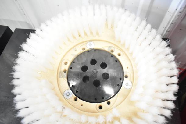 Brand new floor scrubbing machine brush, white bristles, slight scratches; durable construction, ready for use.