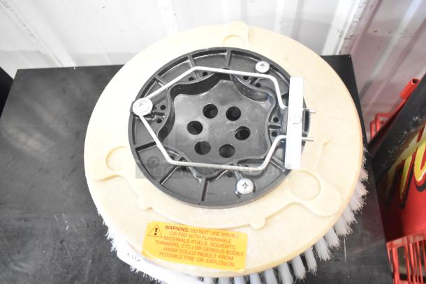 Brand new floor scrubbing machine brush, scratch and dent condition, with attached warning label about flammable materials.