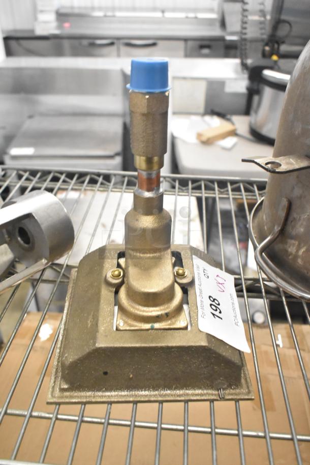 Mixing auger with brass fitting and blue cap on metal shelf. Includes auction tag labeled "198."