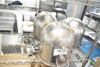 Five items: three stainless steel mixing bowls and two paddle attachments. Visible tag reads "199" from PCI Auctions. Used condition.