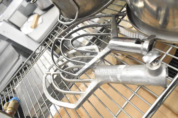 5 items: 3 mixing bowls, 2 metal paddle attachments. Mixing bowls are stainless steel; paddles appear sturdy. Good condition.