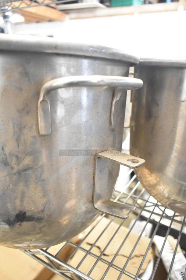 Five items including three stainless steel mixing bowls with handles and two paddle attachments, slightly worn condition.