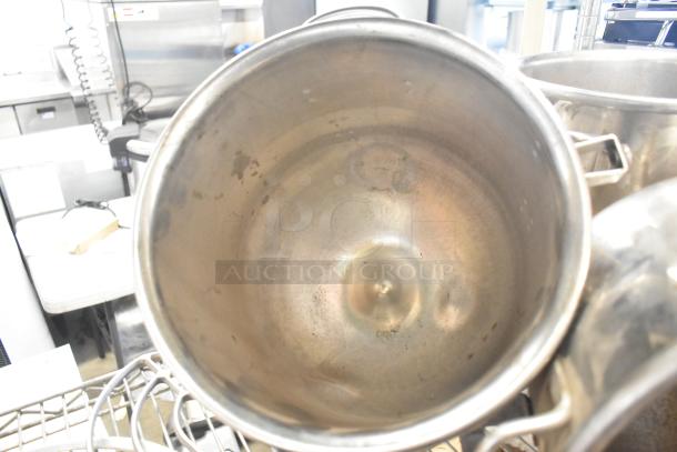 Set of 3 stainless steel mixing bowls and 2 paddle attachments, lightly used, showing some wear, ideal for kitchen use.