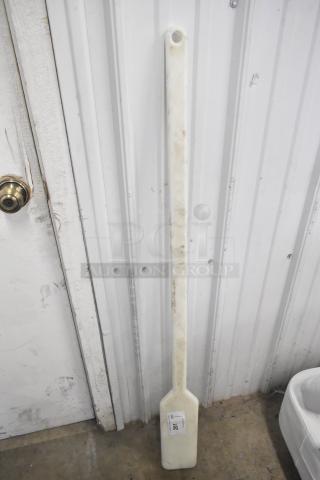 White mixing paddle, long handle with a flat paddle end, in used condition. Item tag reads "Lot 102."