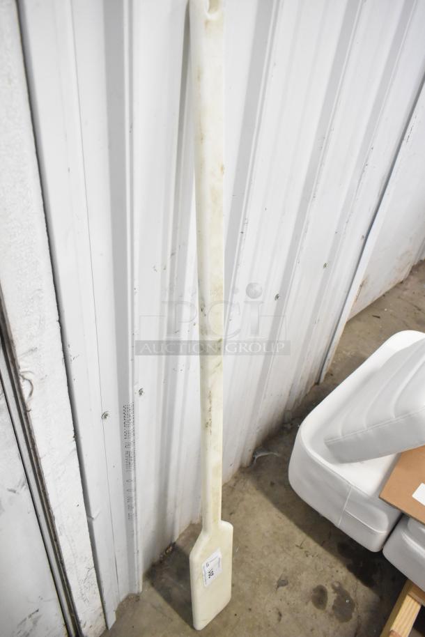 White mixing paddle with rectangular blade, shows signs of use. Marked with an auction label on the blade.