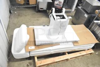 Electronic bed with seat positioning, remote, and heat option. Features a white base, adjustable sections, and cables. Condition: appears new.