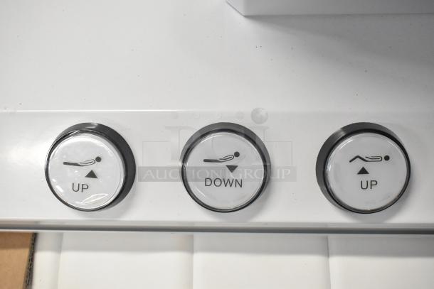 Electronic bed controls featuring seat positioning buttons labeled "Up," "Down," and "Up" with heat option.