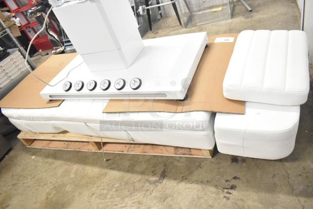 Electronic bed with white upholstery, featuring a seat positioning remote and heat option. New, in excellent condition.