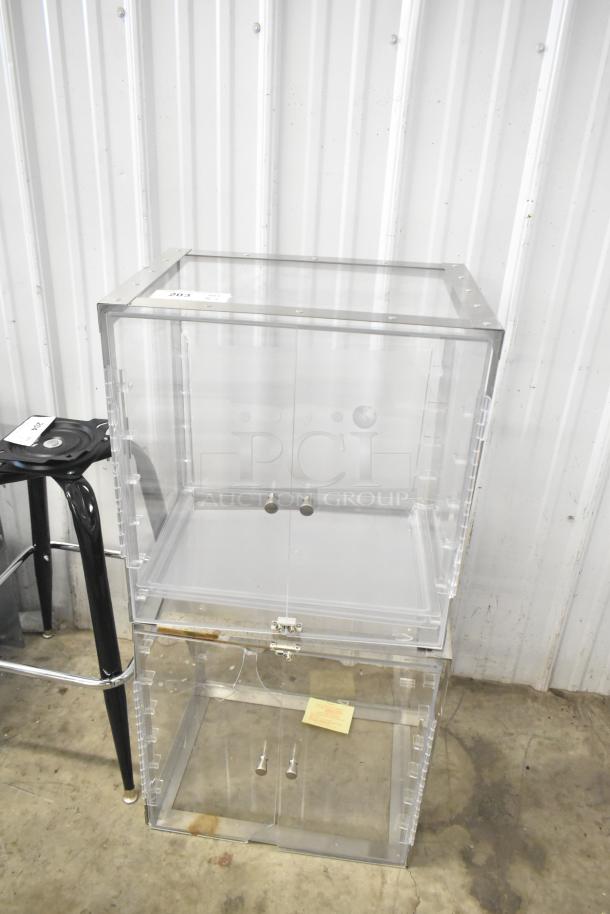 2 clear poly countertop cabinets, stackable design, transparent doors with knobs, slight wear visible, ideal for display.