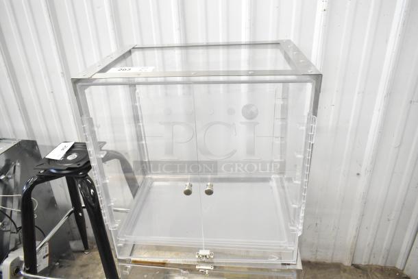 Clear poly countertop cabinet with metal frame, hinged doors, and labels on top. Appears in excellent condition.