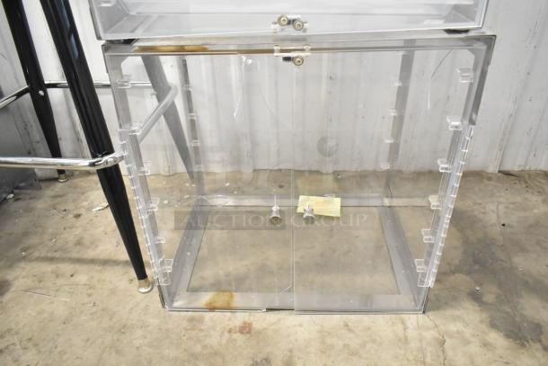 Two clear poly countertop cabinets with front doors and metal knobs, in good condition, industrial setting.