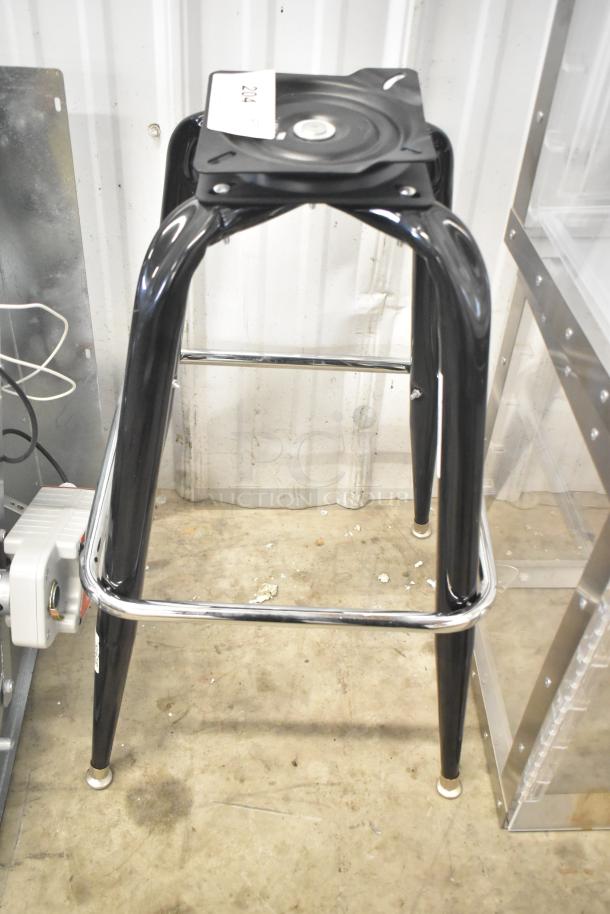 Black metal bar stool base with chrome footrest, labeled "204." In good condition.