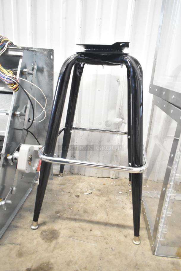Black bar stool base with four sleek metal legs, chrome footrest, and black finish. Good condition. Ideal for modern seating.