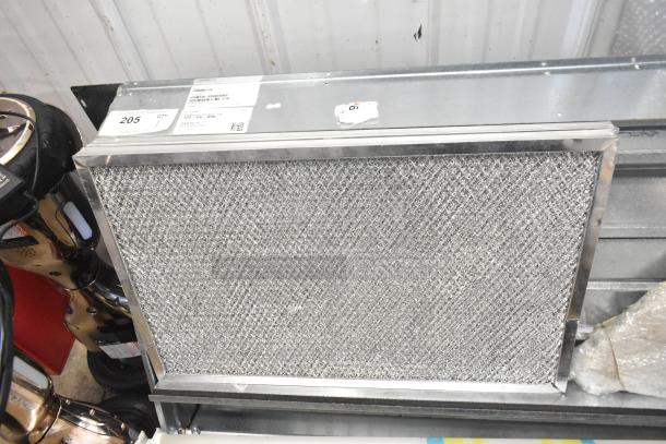 Brand new Daikin hood with McDaniels Metal 122-DK-090 economizer. Vertical/downflow model. Visible tags with model info.