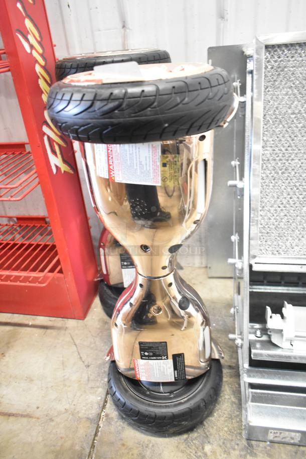 2 Hover-1 Titan HY-TTN hoverboards, gold chrome finish, new condition with visible warning labels.