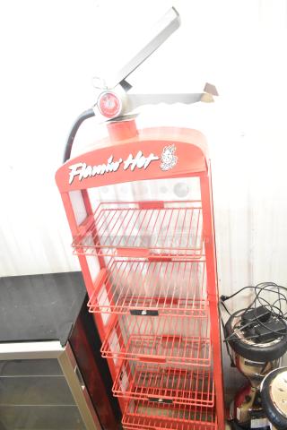 Flamin Hot Cheetos red metal fire extinguisher display, featuring branded graphics and multiple wire shelves.