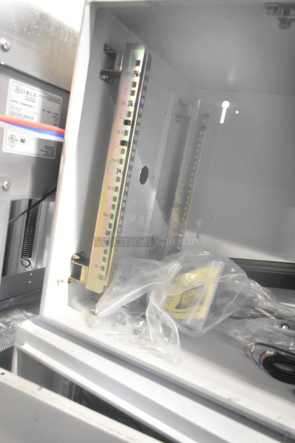 White metal BlackShields DC0300 air-conditioned cabinet, visible internal brackets and wiring, includes labels and installation parts.