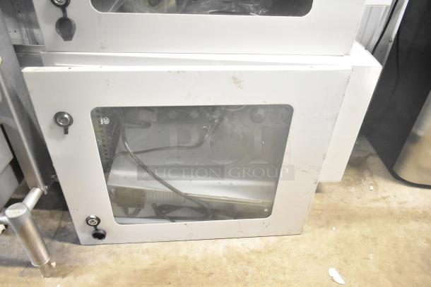 2 BlackShields DC0300 white metal air-conditioned cabinets with glass doors, visible wiring, and secure locks; shows some wear.