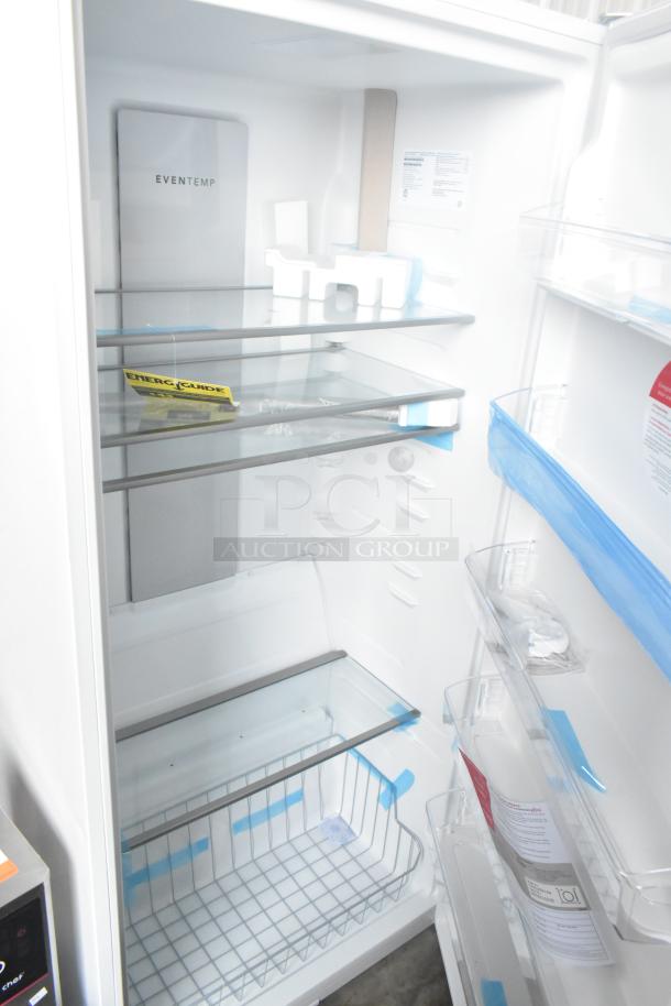 Brand new Frigidaire FRAE2024AWB reach-in cooler, 115 volts, 1 phase. Scratch and dent condition, glass shelves, energy guide visible.