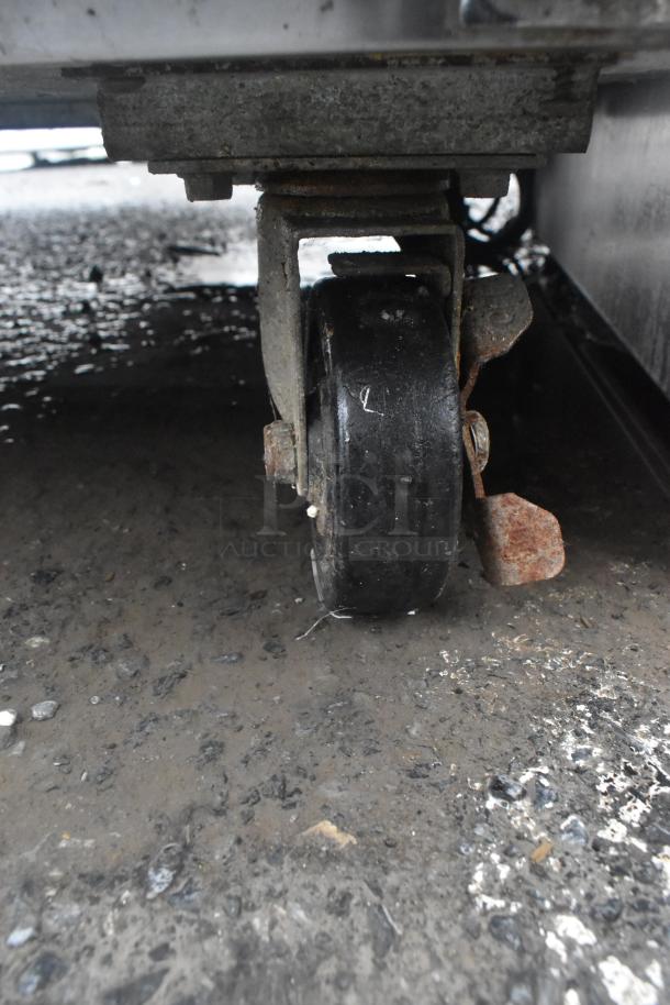 Avantco 178SSUC48FHC commercial freezer caster, showing a close-up of the wheel on a textured surface, moderate wear.