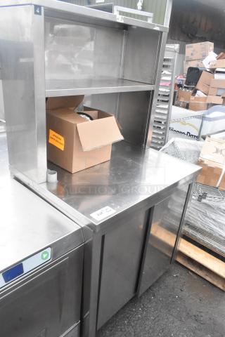 Commercial counter with 2 lower doors, under shelf, over shelf, and commercial casters, in used condition.