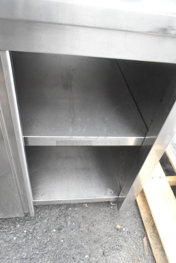 Commercial counter with two lower doors, under shelf, over shelf, on commercial casters. Used condition.