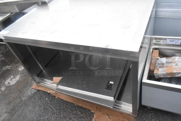 BRAND NEW Regency 600EBT3048D 30"x48" stainless steel table, type 304, with sliding doors, adjustable midshelf, visible dents.