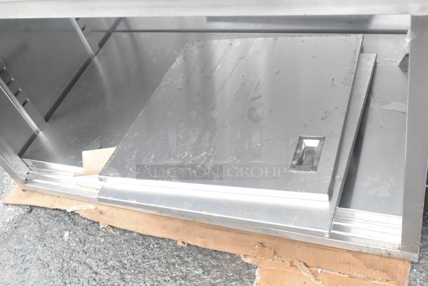 BRAND NEW scratched Regency 30"x48" 16-gauge Type 304 stainless steel table with sliding doors, adjustable midshelf.