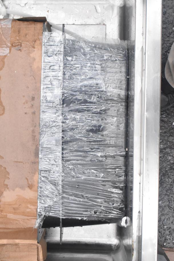 Brand new Regency 600IB1824CP underbar ice bin with protective wrapping, features cold plate, bottle holders, minor scratches.