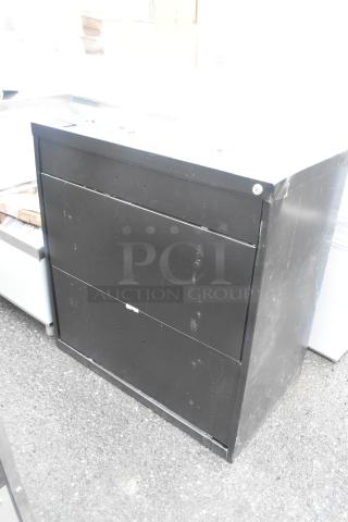 Brand new black 2-drawer filing cabinet with visible scratches and dents, suitable for office storage.