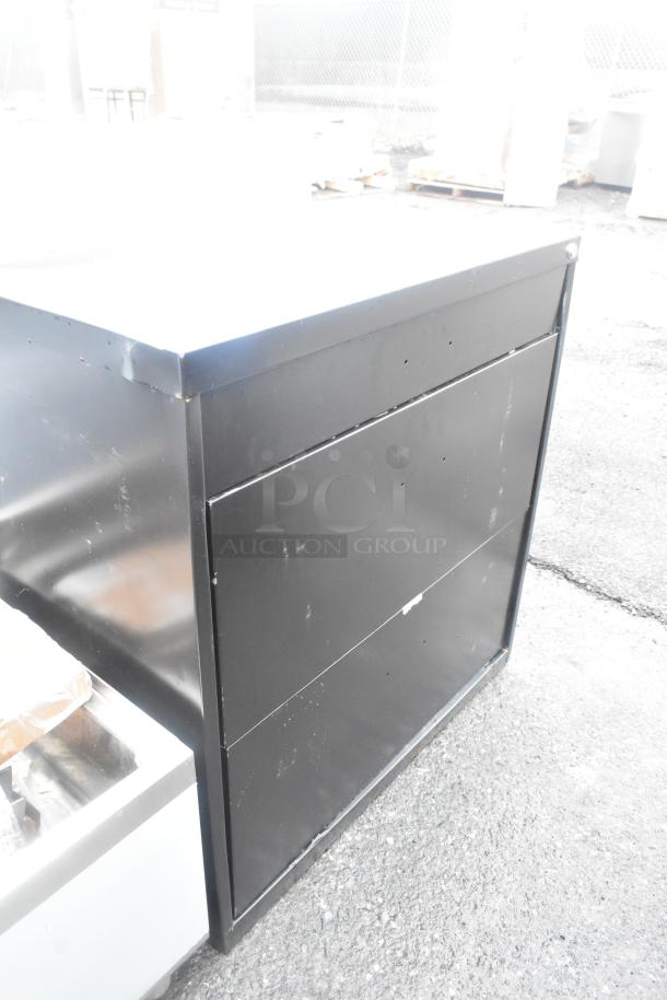 Brand new black 2-drawer filing cabinet with visible scratches and dents. Durable metal construction. No tags visible.