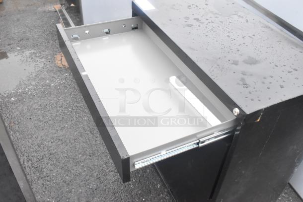 Brand new black 2-drawer filing cabinet with visible dents. Scratch-resistant finish, spacious drawers, minor exterior blemishes.