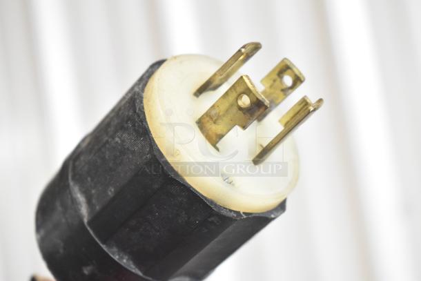 Close-up image of a power plug for the Taylor C723-27 soft serve ice cream machine, showing metal prongs and a black, durable casing.