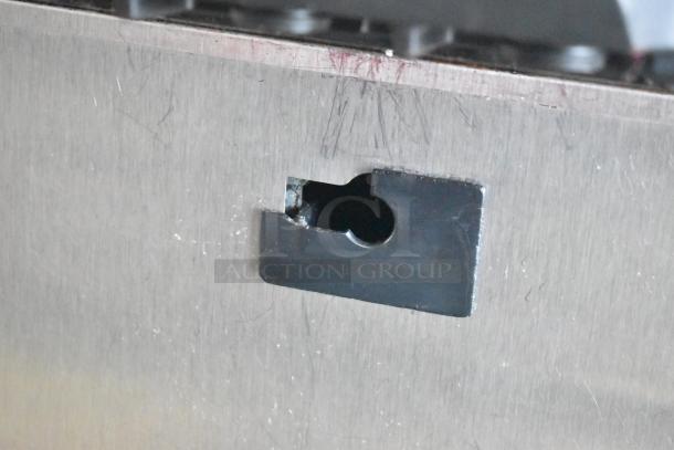 Close-up of a Taylor C723-27 ice cream machine's stainless steel surface showing wear, with a visible mounting bracket.