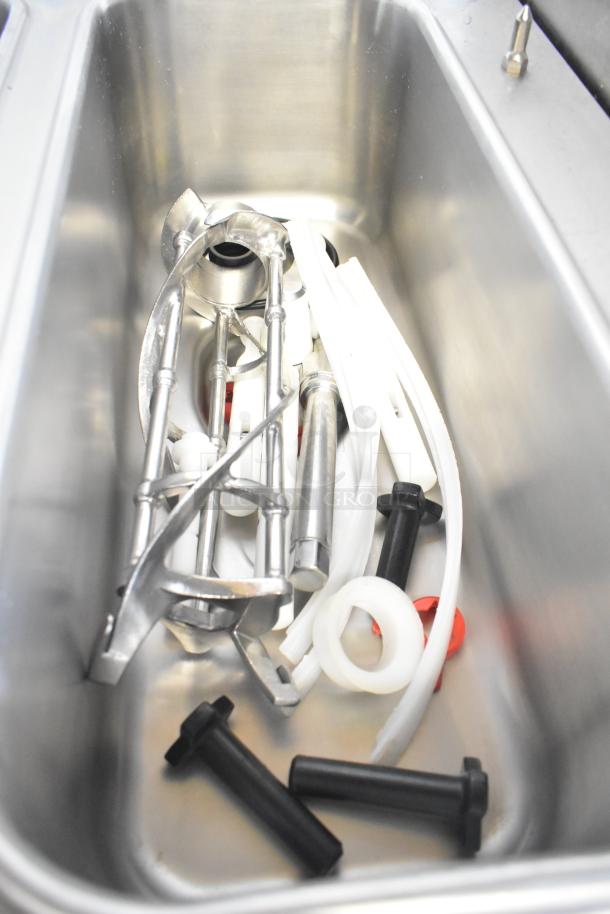 Components of Taylor C723-27 soft serve machine in stainless steel tub; includes various metal parts and seals.