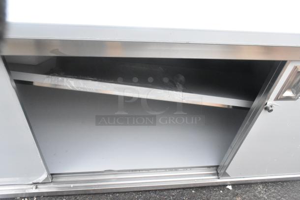 Regency 600EBTB3096D 30"x96" stainless steel table with sliding doors, adjustable midshelf, 6" backsplash; scratch and dent condition.