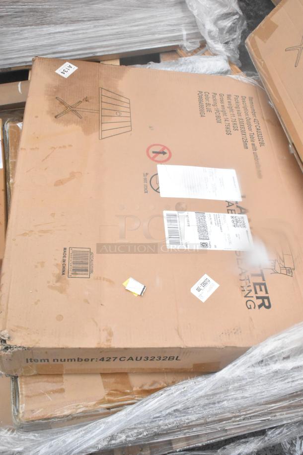 Cardboard box with "Item number: 427CAU3232BL" visible, containing scratch and dent wall corner guards, outdoor tables, shelves. Box shows manufacturing and shipping labels.