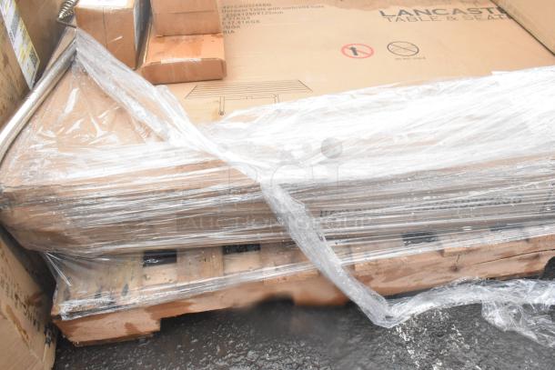 Brand new scratch and dent items on a pallet, wrapped in plastic. Includes Lancaster table and wall corner guards.