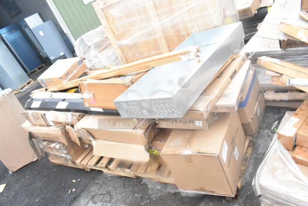 Stack of 24 new scratch and dent items, including a wall corner guard, work table, and tray stand, on pallets.