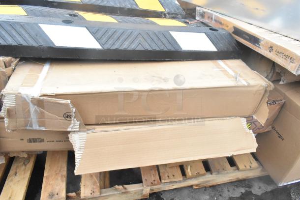 24 brand new scratch and dent items including wall corner guard, work table, tray stand on pallets with visible packaging wear.