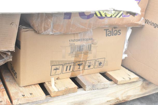 Cardboard boxes labeled "Talos" on a wooden pallet, showing minor damage. Contains new items like wall corner guards and work tables, marked as "178TOWERQUAD."