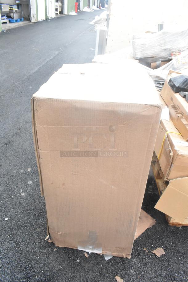 Cardboard box containing a new Lancaster Table & Seating metal green cafe bar stool frame with scratches and dents.