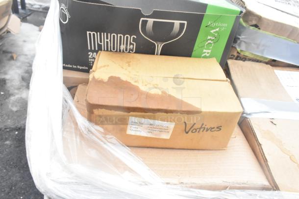 Boxes of assorted glassware and dishes, labeled "Mykonos" and "Votives," showing signs of wear. Includes 34 new items.
