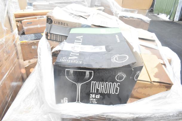 Boxes of new glassware and dishes, brands include Libbey and Cortefino, sealed in plastic wrap, scratch and dent condition.