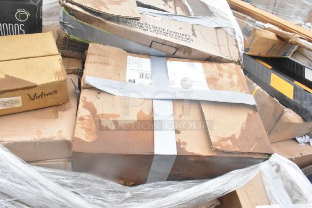 Boxes labeled "Votives" and "Corte Rigo" with signs of wear, indicating scratch and dent glassware and dishes.