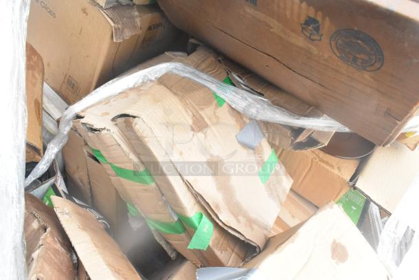 Boxes of scratch and dent glassware and dishes, wrapped in plastic, showing signs of wear and tear.