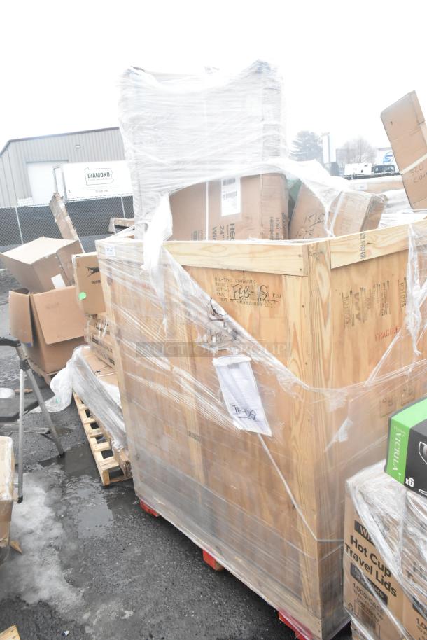 Shrink-wrapped pallet with multiple boxed items including a wooden crate, labeled as brand new scratch and dent items.